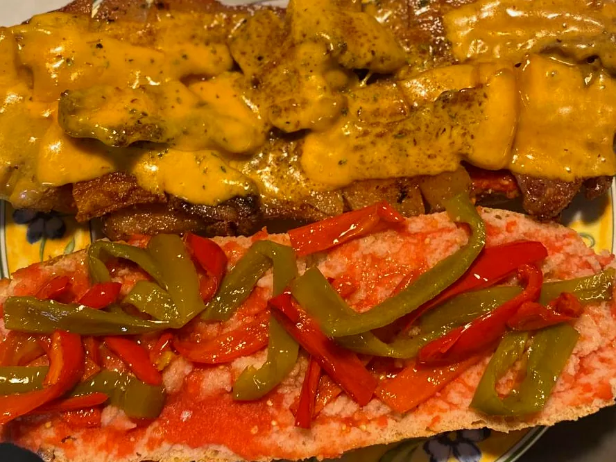 Bocadillo abierto de la casa con carne, salsa y pimientos asados
