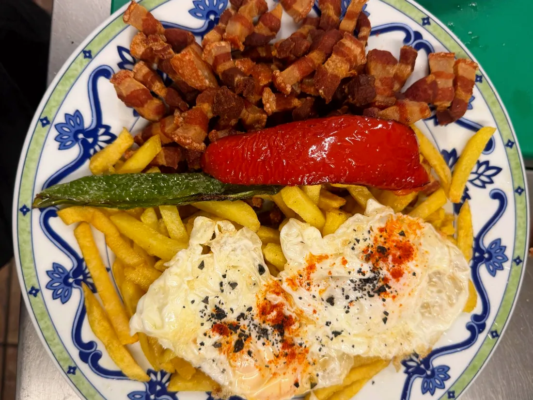 Plato combinado con huevos fritos, patatas, pimiento rojo y torreznos